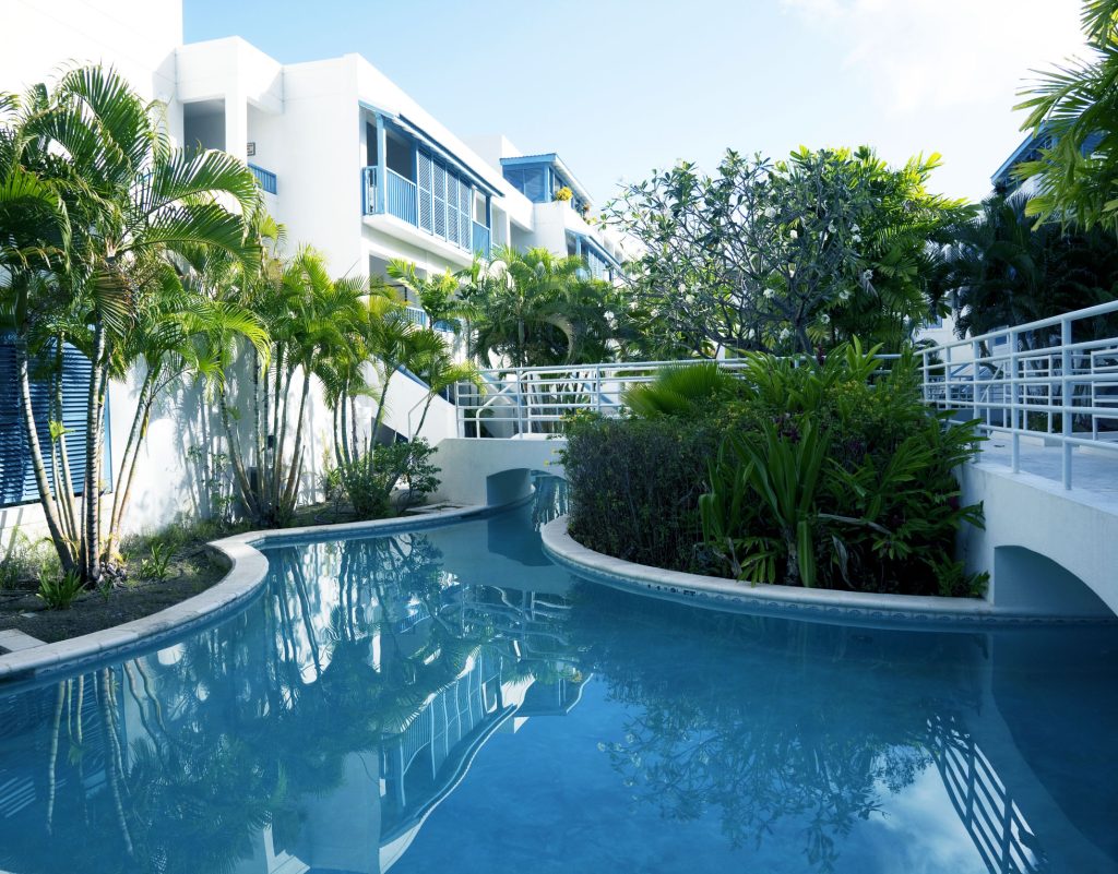"Holiday accommodation in Bridgetown, Barbados with palm trees, footpaths and swimming pool."